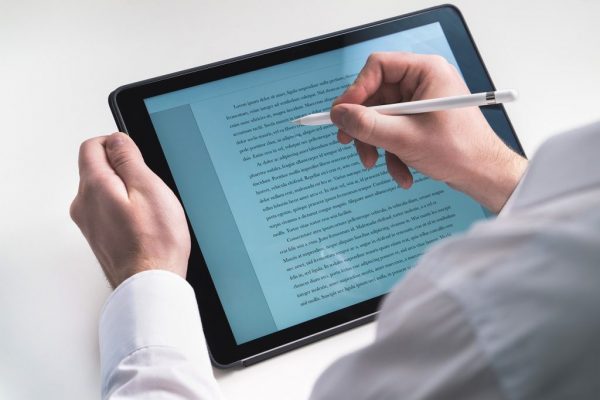 person writing on a tablet with stylus